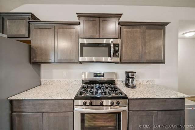 kitchen featuring light stone countertops, dark brown cabinets, and appliances with stainless steel finishes