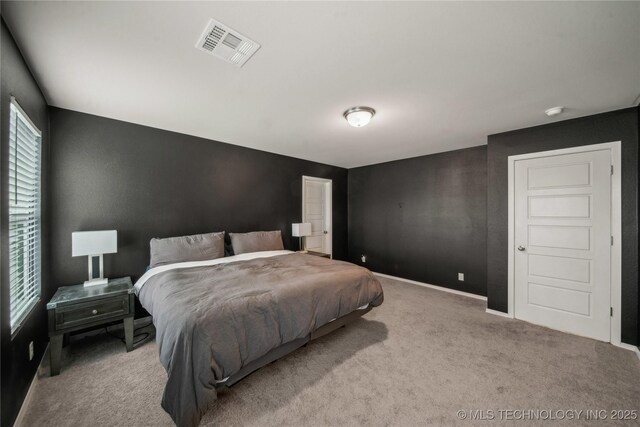 carpeted bedroom featuring baseboards and visible vents