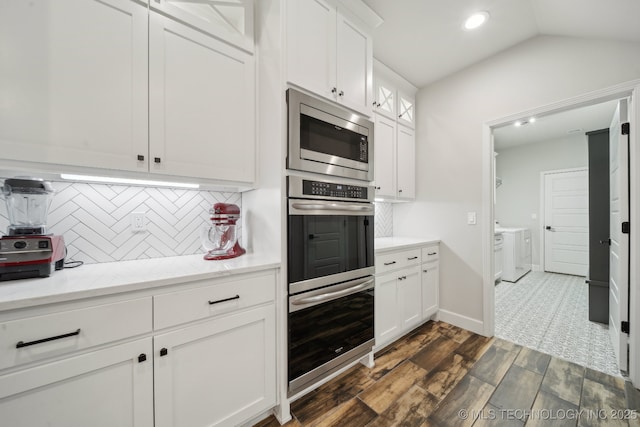 1992 E 173rd St S, Mounds, OK 74047 - kitchen with dark wood-style floors, white cabinetry, tasteful backsplash, separate washer and dryer, and stainless steel appliances