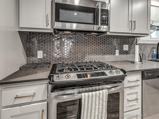 1805 W Easton St, Tulsa, OK 74127 - kitchen featuring appliances with stainless steel finishes, decorative backsplash, white cabinets, and dark countertops