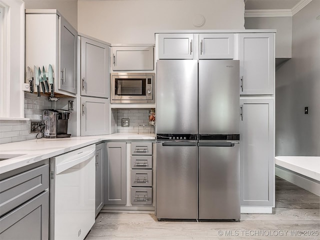 1805 W Easton St, Tulsa, OK 74127 - kitchen with appliances with stainless steel finishes, gray cabinetry, ornamental molding, light wood-style flooring, and light stone counters