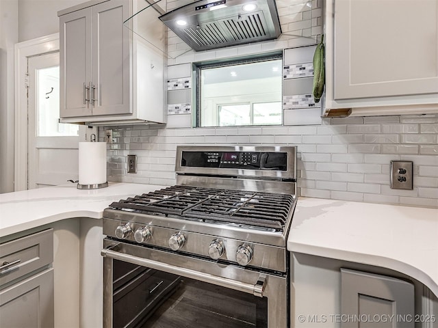 1805 W Easton St, Tulsa, OK 74127 - kitchen with stainless steel gas stove, custom range hood, gray cabinetry, backsplash, and light stone countertops