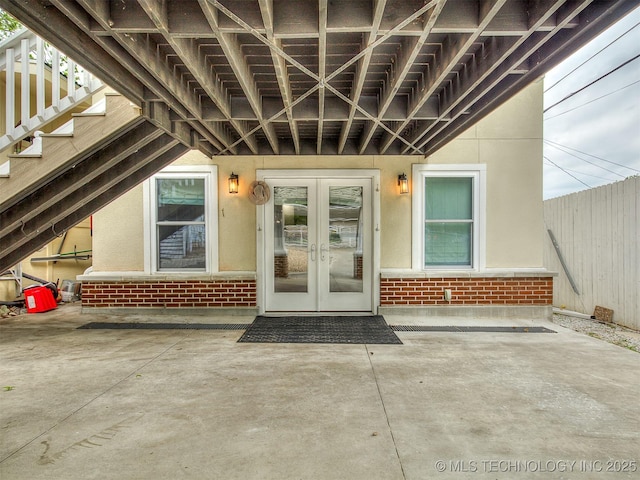1805 W Easton St, Tulsa, OK 74127 - view of exterior entry with french doors, brick siding, a patio area, and stucco siding