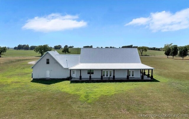 back of property with a lawn, metal roof, and french doors