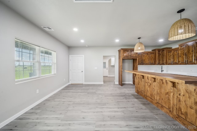 kitchen with recessed lighting, baseboards, light wood-type flooring, visible vents, and pendant lighting