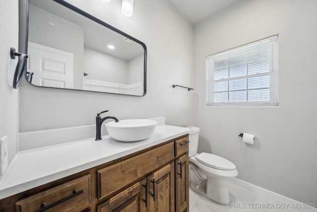 bathroom featuring vanity, marble finish floor, baseboards, and toilet