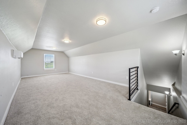 bonus room with baseboards, vaulted ceiling, carpet, and a wall mounted air conditioner