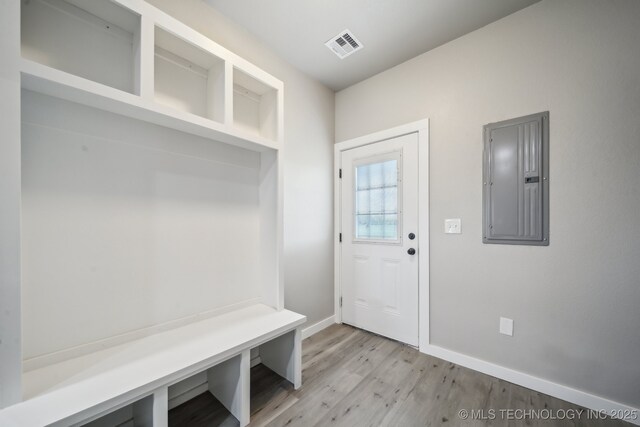 mudroom with baseboards, electric panel, light wood-style flooring, and visible vents