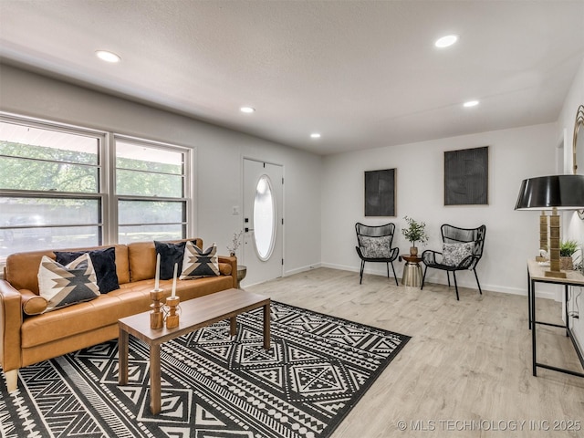 living room with recessed lighting, light wood-style flooring, and baseboards