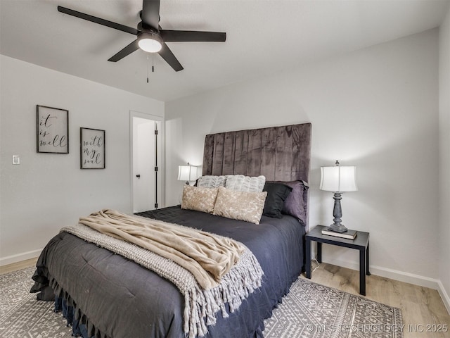 bedroom with a ceiling fan, wood finished floors, and baseboards