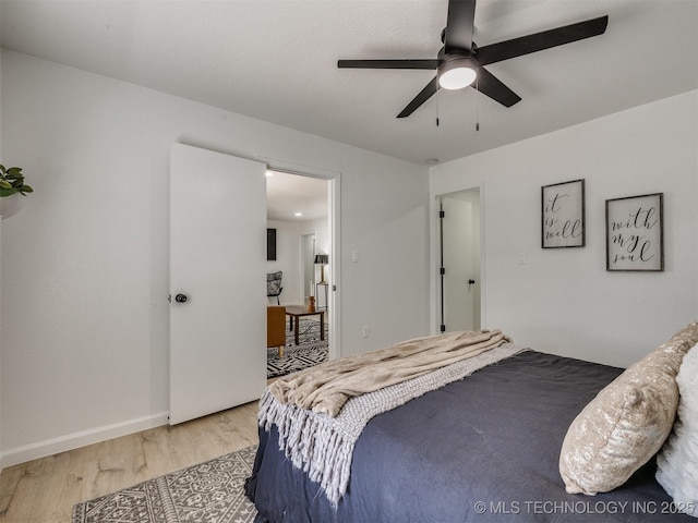 bedroom featuring light wood finished floors, ceiling fan, and baseboards
