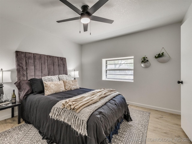 bedroom with baseboards, wood finished floors, and a ceiling fan