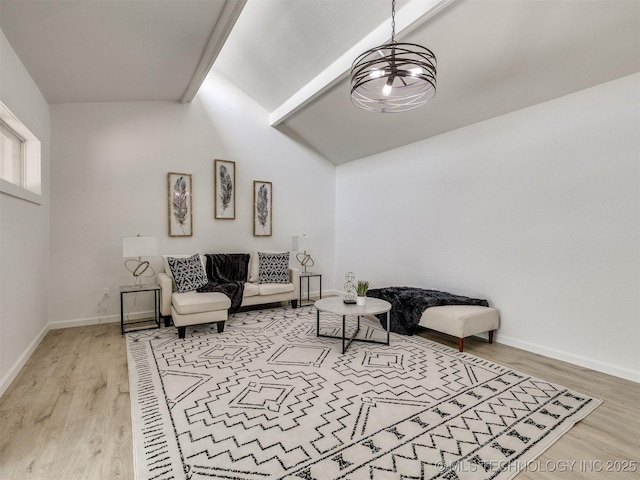living area with lofted ceiling, an inviting chandelier, light wood-type flooring, and baseboards