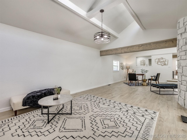 interior space featuring baseboards, wood finished floors, and vaulted ceiling with beams
