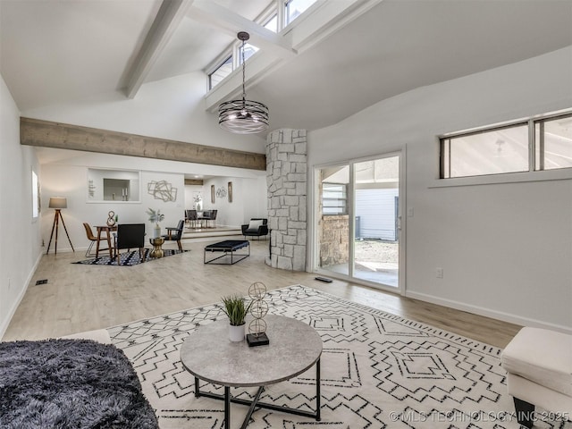 living area featuring baseboards, visible vents, lofted ceiling with beams, and wood finished floors