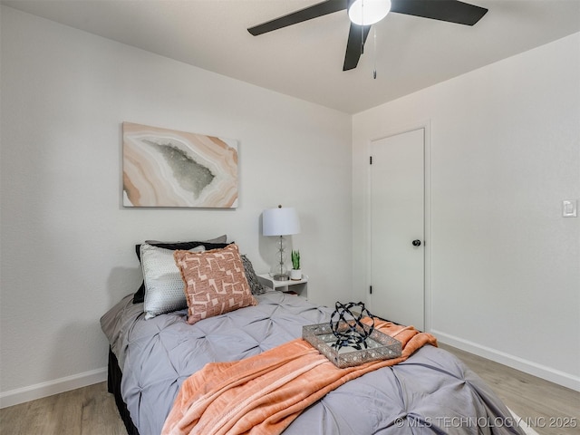 bedroom with baseboards, wood finished floors, and a ceiling fan