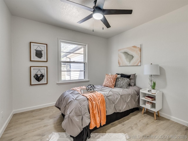 bedroom with a ceiling fan, wood finished floors, and baseboards