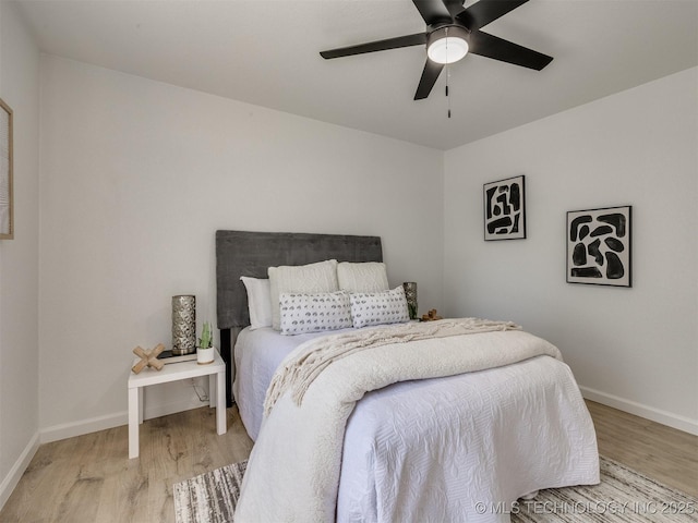 bedroom featuring ceiling fan, light wood-type flooring, and baseboards