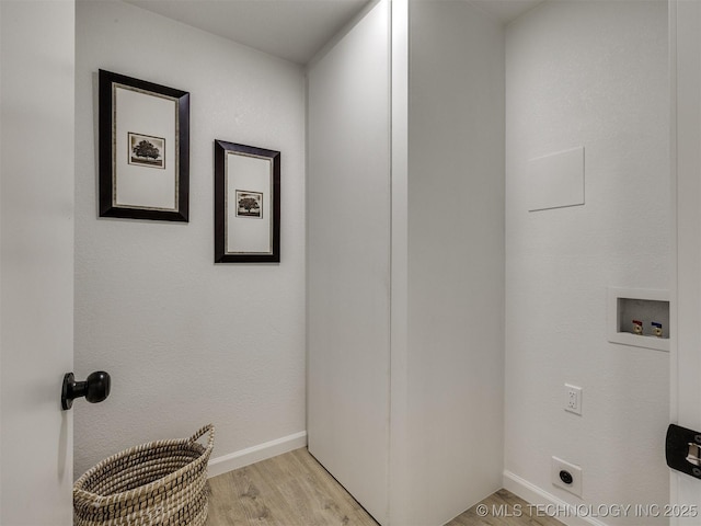 laundry area with hookup for a washing machine, laundry area, electric dryer hookup, light wood finished floors, and baseboards
