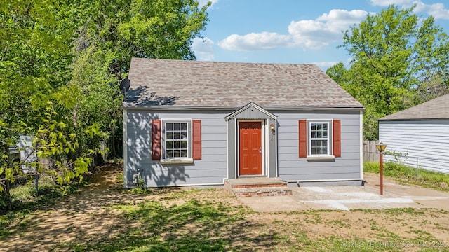 view of front of property with fence and roof with shingles