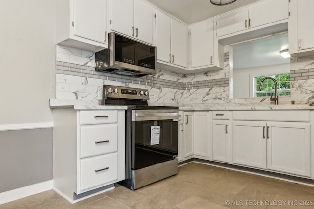 kitchen featuring white cabinets, appliances with stainless steel finishes, a sink, and tasteful backsplash
