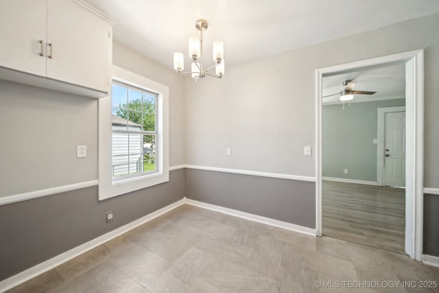 unfurnished dining area with baseboards and ceiling fan with notable chandelier