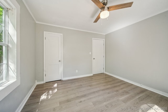 unfurnished bedroom with baseboards, ornamental molding, light wood finished floors, and a ceiling fan
