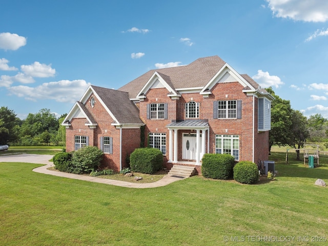 view of front of house with a front yard, central AC, and brick siding
