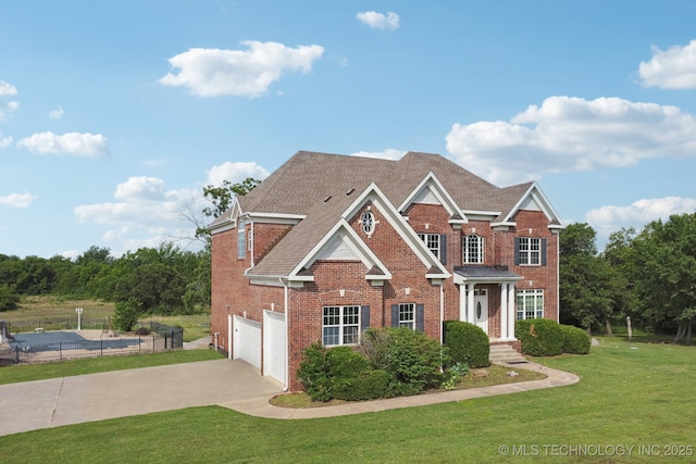 view of front facade with brick siding, fence, a front lawn, and concrete driveway