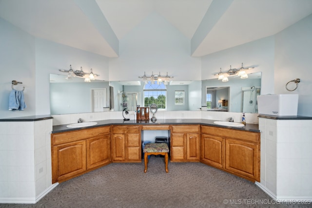 bathroom featuring a stall shower, high vaulted ceiling, and vanity