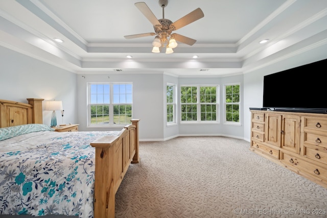 bedroom with crown molding, light colored carpet, and a tray ceiling