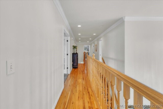 hallway with crown molding, recessed lighting, light wood-style flooring, and an upstairs landing
