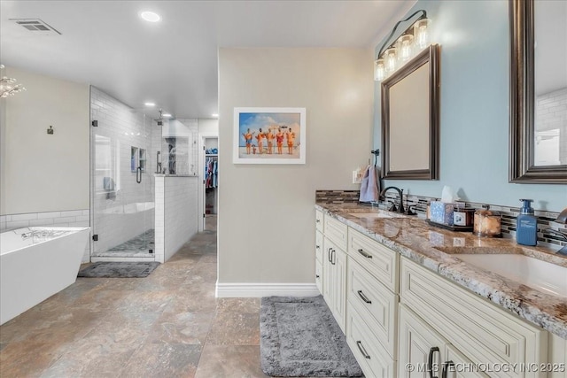 bathroom featuring visible vents, a sink, a freestanding tub, and a shower stall