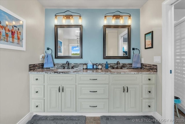 bathroom with double vanity, baseboards, and a sink