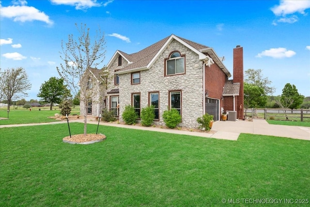 view of front of home featuring fence, a front lawn, stone siding, a chimney, and driveway