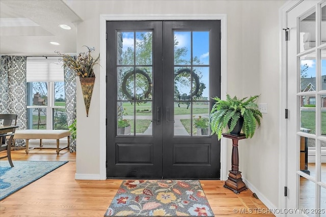 doorway with baseboards, french doors, and wood finished floors