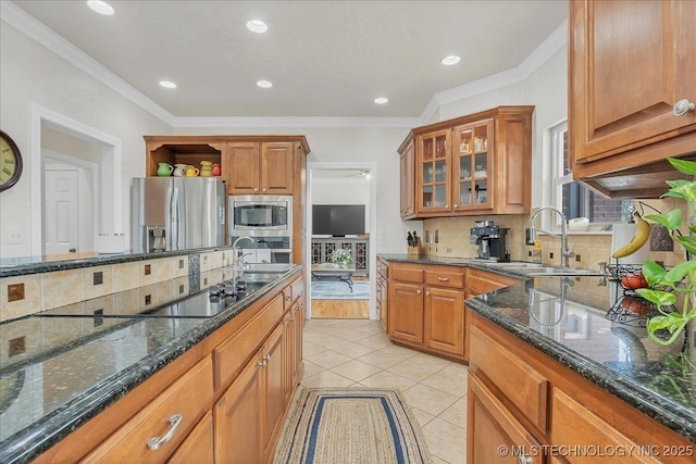 kitchen with dark stone counters, appliances with stainless steel finishes, decorative backsplash, and a sink