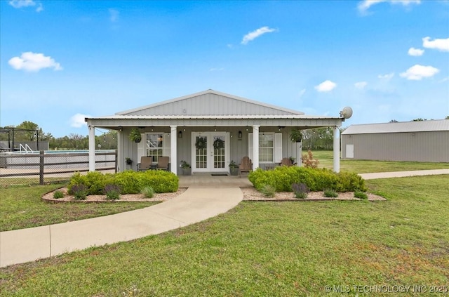 exterior space with fence, a front yard, french doors, board and batten siding, and a porch