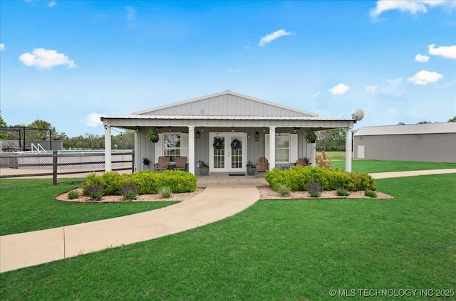 view of front of property with french doors, fence, board and batten siding, and a front yard