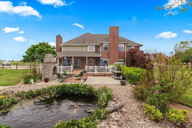 back of house with fence, a patio, and a chimney