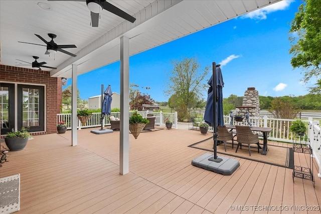wooden deck featuring outdoor dining area and a ceiling fan