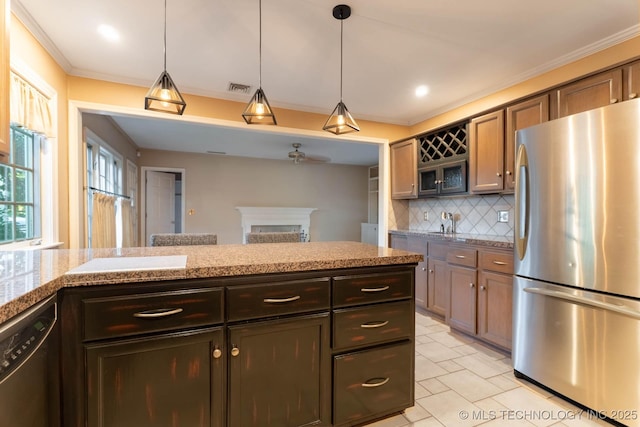 3505 S Birmingham Ave, Tulsa, OK 74105 - kitchen featuring stainless steel appliances, tasteful backsplash, a fireplace, ceiling fan, and hanging light fixtures