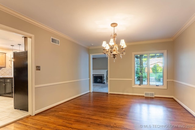 3505 S Birmingham Ave, Tulsa, OK 74105 - empty room with light wood finished floors, a chandelier, a fireplace, and crown molding