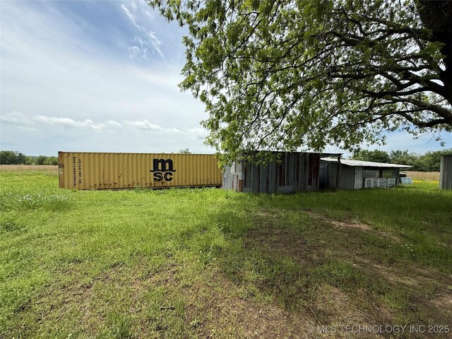 view of yard featuring an outdoor structure and an outbuilding