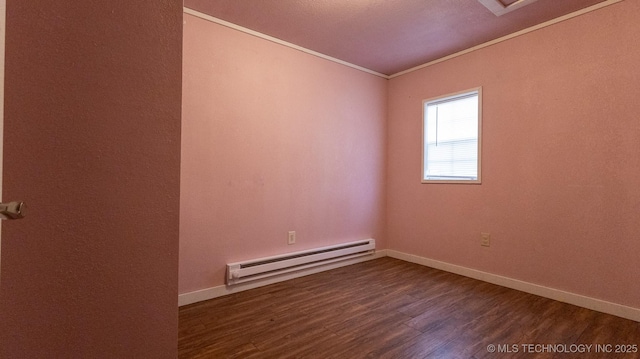 spare room featuring baseboard heating, baseboards, dark wood-style flooring, and crown molding