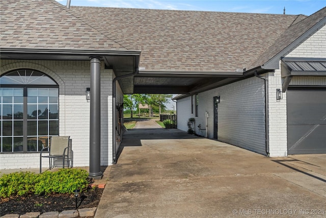 view of home's exterior with brick siding, a shingled roof, and concrete driveway