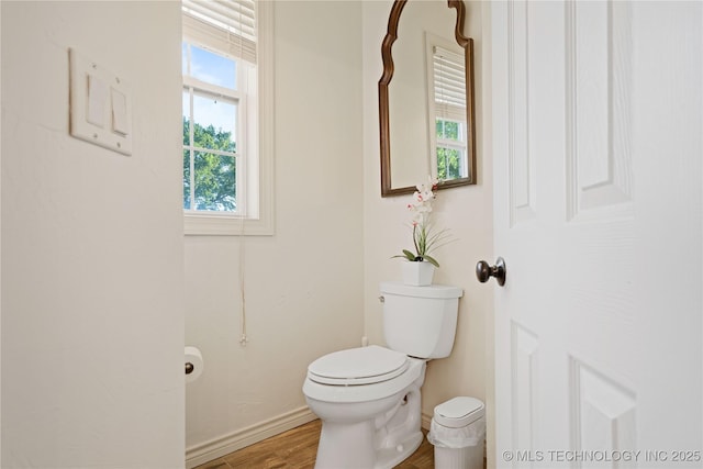 bathroom with wood finished floors, toilet, and baseboards