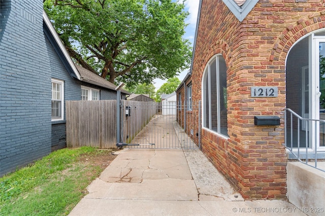 1212 S Knoxville Ave, Tulsa, OK 74112 - view of side of property with a gate, brick siding, fence, and stone siding