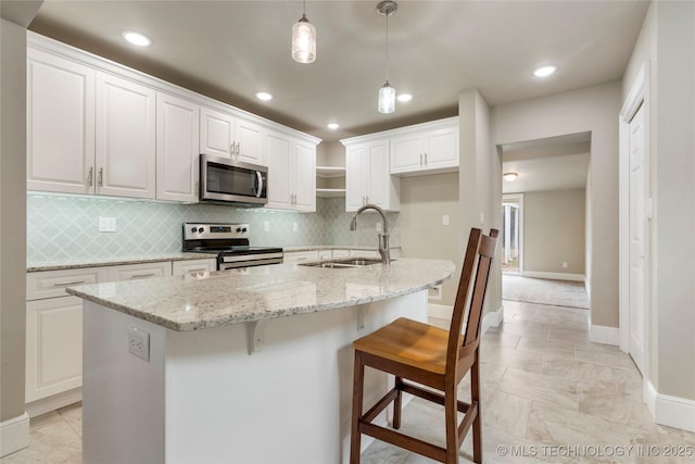 1212 S Knoxville Ave, Tulsa, OK 74112 - kitchen featuring tasteful backsplash, a sink, stainless steel appliances, baseboards, and decorative light fixtures