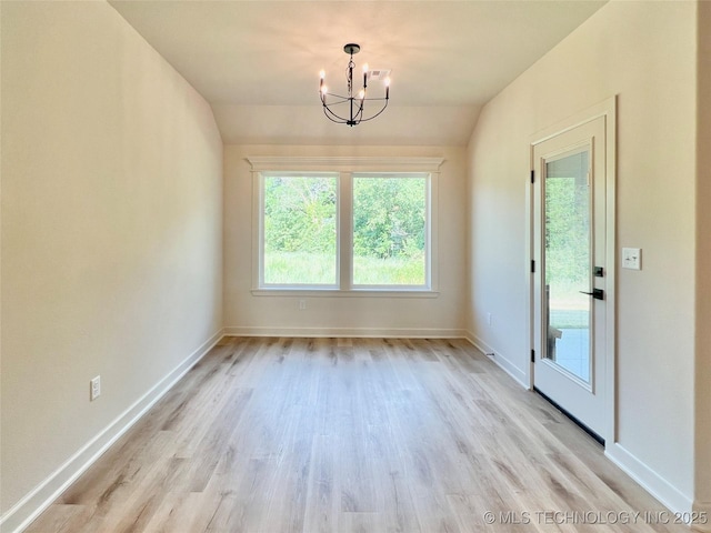 unfurnished dining area with light wood finished floors, an inviting chandelier, visible vents, baseboards, and lofted ceiling